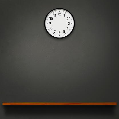wall clock above the wooden shelf on dark concrete wall with copy space.
