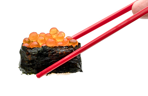 rolled sushi of salmon roe nigiri with red chopsticks isolated on white background