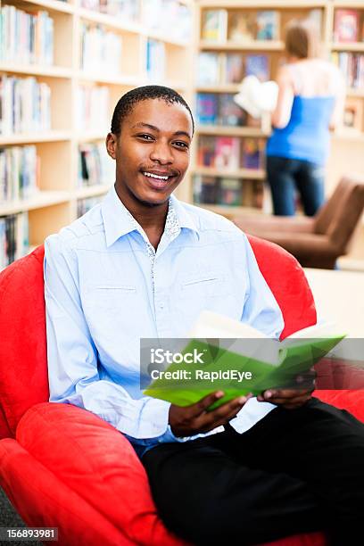 Happy Young Student Sits And Studies In Campus Library Stock Photo - Download Image Now