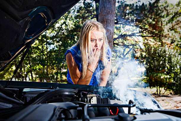 istock Desperate blonde babe looks at smoking car engine in horror 156894312