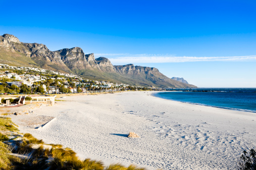 Camps Bay beach, Cape Town, framed by the Twelve Apostles, part of the Table Mountain range, rising behind the wealthy seaside suburb and nightlife strip.