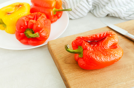 The process of preparing a salad with large red and yellow roasted peppers. Concept Traditional Italian dish. Vegetarian and vegan food. Horizontal orientation.