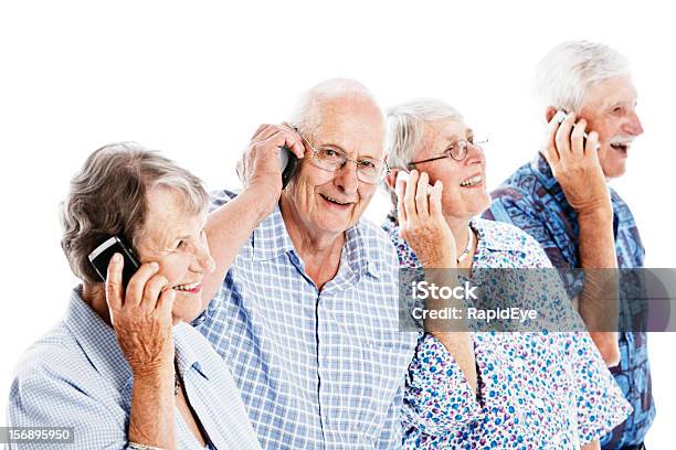 Cuatro Sonriendo Seniors Manténgase En Contacto Con Teléfonos Móviles Foto de stock y más banco de imágenes de 70-79 años