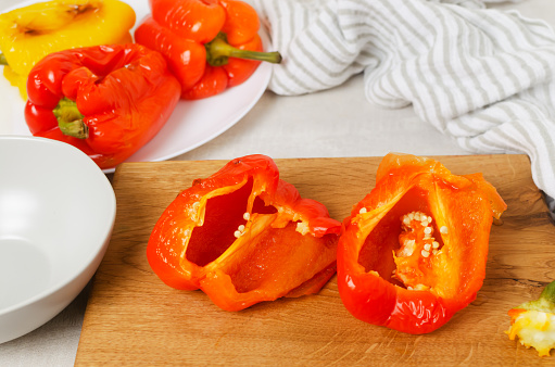 The process of preparing a salad with large red and yellow roasted peppers. Concept Traditional Italian dish. Vegetarian and vegan food. Horizontal orientation.