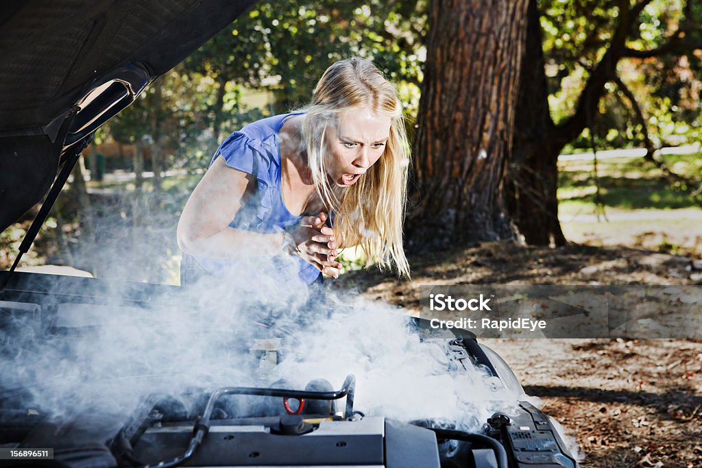 Per torcerci le mani, bella bionda gasps con motore di fumo auto - Foto stock royalty-free di Automobile