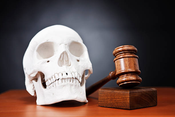 istock Human skull with judge's gavel on black: harsh justice 156896572