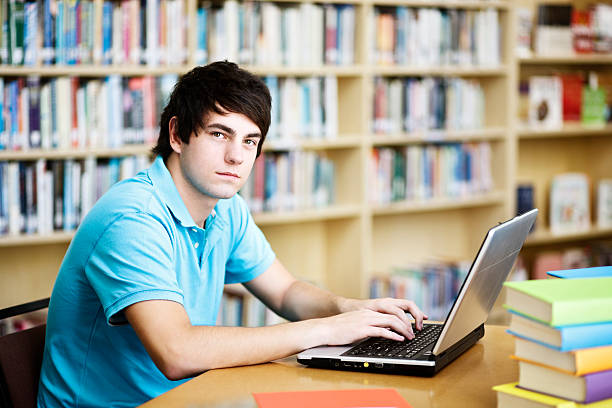 istock Handsome, serious student in library looks up from laptop studies 156896828