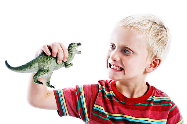 istock 6 year old blond boy confronts tyrannosaurus rex 156897081