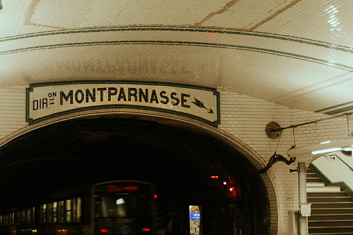 Paris, France - May 20, 2023: Line A of Paris Métro, directed to Montparnasse. The Paris Métro (French: Métro de Paris, short for Métropolitain) is a rapid transit system in the Paris metropolitan area, France. A symbol of the city, it is known for its density within the capital's territorial limits, uniform architecture and unique entrances influenced by Art Nouveau. The system is 226.9 kilometres (141.0 mi) long, mostly underground.\nLine A would join Montmartre to Montparnasse as an additional north–south line to the west of Line 4.