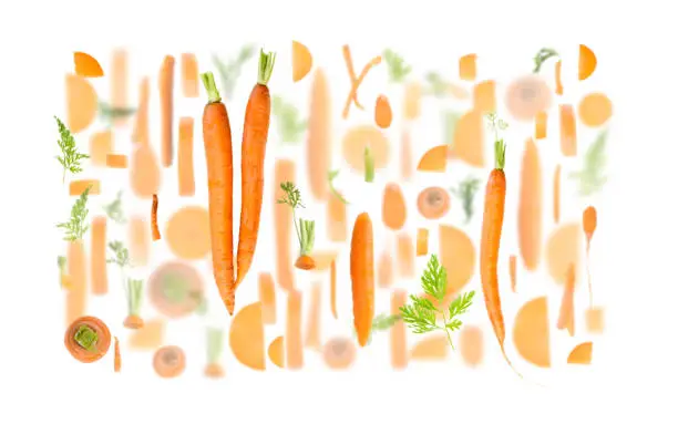 Abstract background made of Carrot fruit pieces, slices and leaves isolated on white.