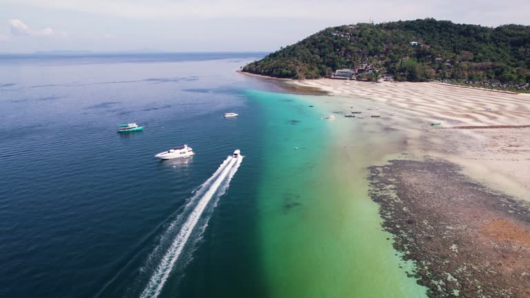 Aerial view of boat moving beside corals with clear water