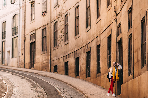 Typical streets of Lisbon, Portugal. girl posing near the wall of the building.