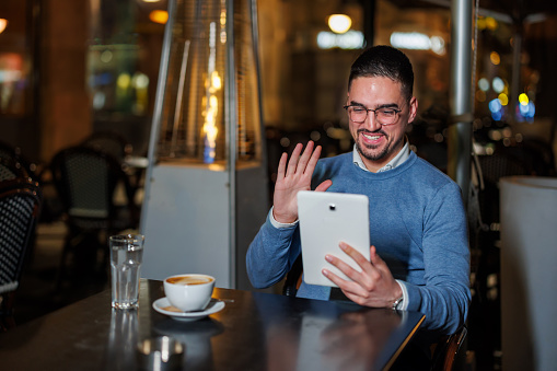 Mid-Adult Man Seamlessly Integrating Tablet Use in a Cafe Setting
