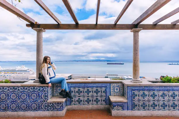 Photo of A female tourist sits with her eyes closed on a panoramic platfo