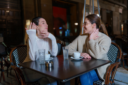 Two Female Friends Engrossed in Meaningful Discussion at a Café