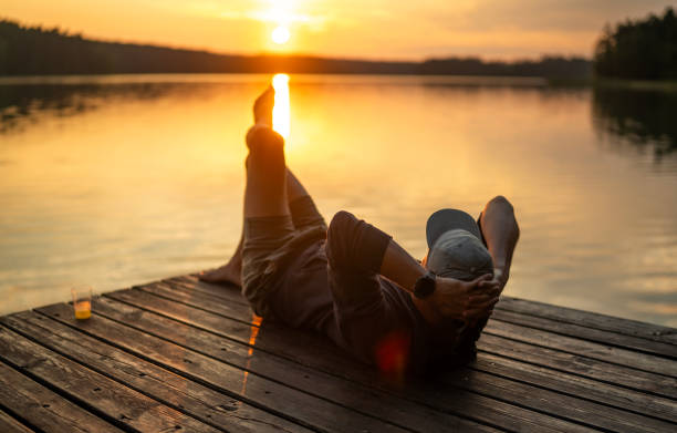 istock Man observing a golden sunset over a lake 1569047561