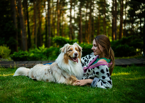 Woman and her dog playing out in the park or a backyard. Love between pet and its owner