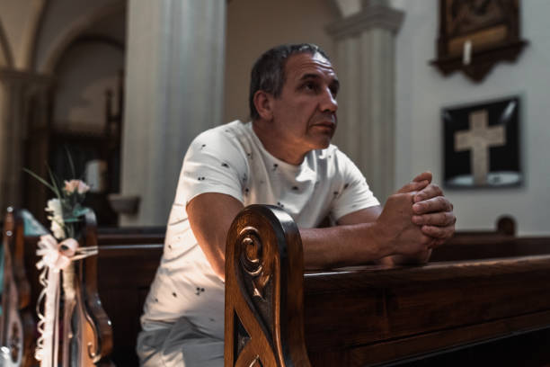 istock man praying in church 1569111428