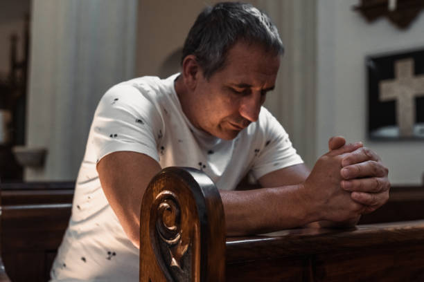 istock man praying in church 1569114667