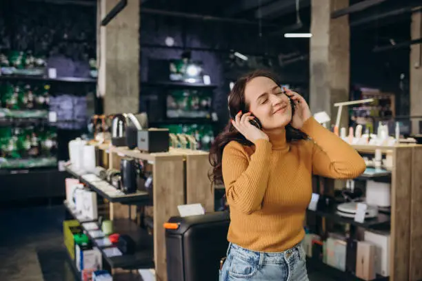 Woman trying on headphones in acoustics store
