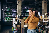 Woman trying on headphones in acoustics store