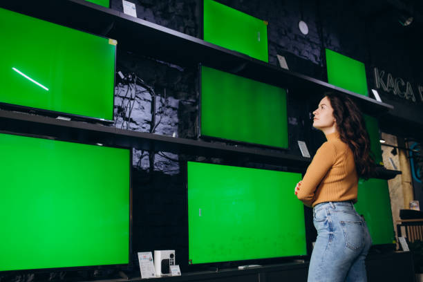 istock a beautiful woman in an electronics store chooses a TV 1569125893