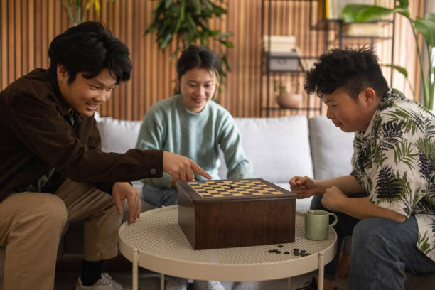 istock Two young men playing checkers at home 1569130315