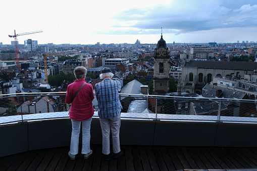 An elderly couple enjoy the view of Brussels during a cloudy day from new Town Hall, Belgium on July 15, 2023.