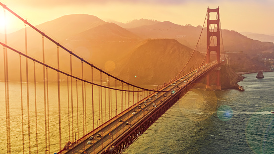 Aerial view of traffic moving on Golden Gate Bridge during sunset, San Francisco, California, USA.