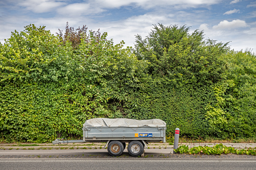 Værløse, Copenhagen, Denmark - July 19th 2023: Trailer for a car in front of a hedge, it is normal in Danish suburbs to have hedges round the house and garden to protect the privacy of the residents