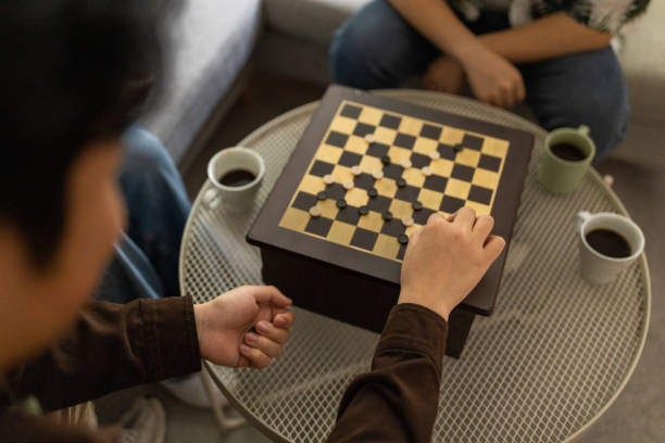 istock Two young men playing checkers at home 1569150123