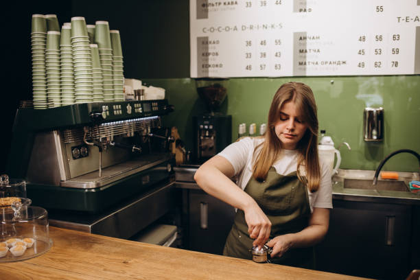 istock barista tempering ground coffee into espresso pitcher. 1569151197