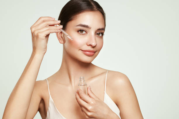 istock Young beautiful woman applying face serum 1569174395