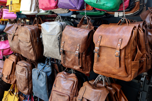 Large group of leather bags and rucksacks in a store.