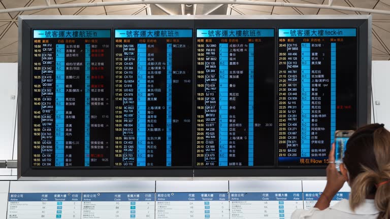 Time lapse flight arrival departure information board, Asian tourist traveler people walk at Hong Kong international airport terminal. Oversea transportation, airline transport business, Asia travel