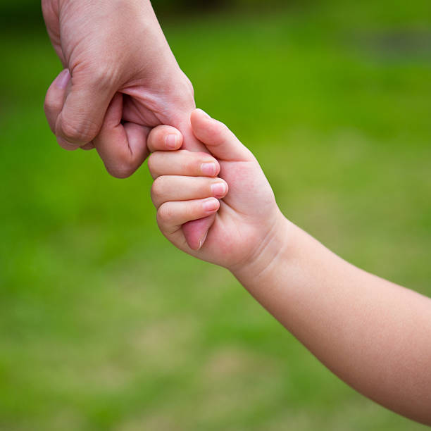 istock A baby holding on to a finger  156919486