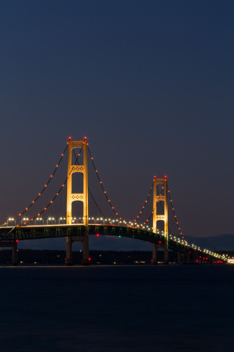 A long suspension bridge illuminated at night.