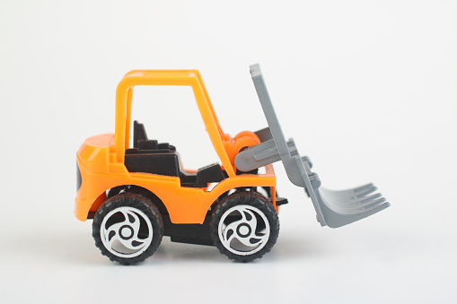 Toy forklift loader isolated on white background. moving service and distribution products. Delivery production. Logistics and industrial concept