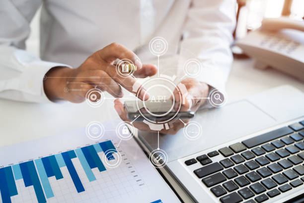istock Modern technology and networking concept, woman using laptop, tablet and smartphone with virtual screen API icon Software development tool. API Application Programming Interface. 1569228726