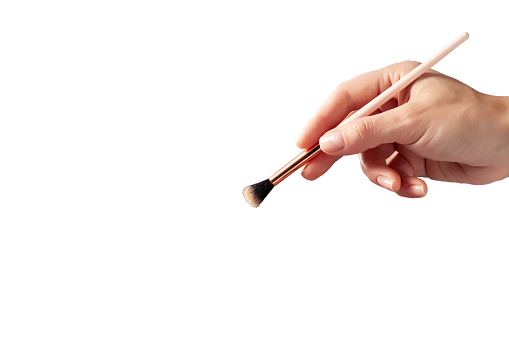 Female hand with brush for make-up. Hand holding paint brush. Brush in the hand. Isolated on white background