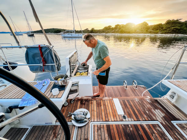 istock Sailing crew member preparing dinner on sailboat 1569249155