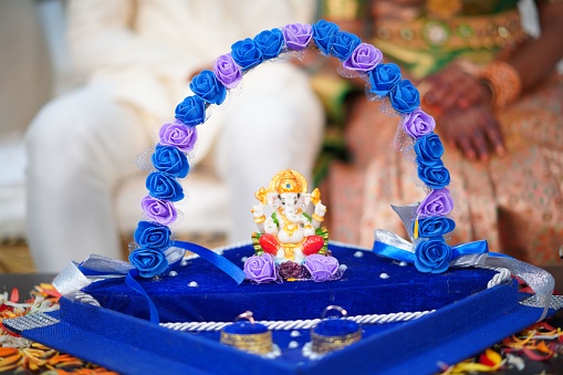 A blue Krishna god decoration with a marriage couple on the background