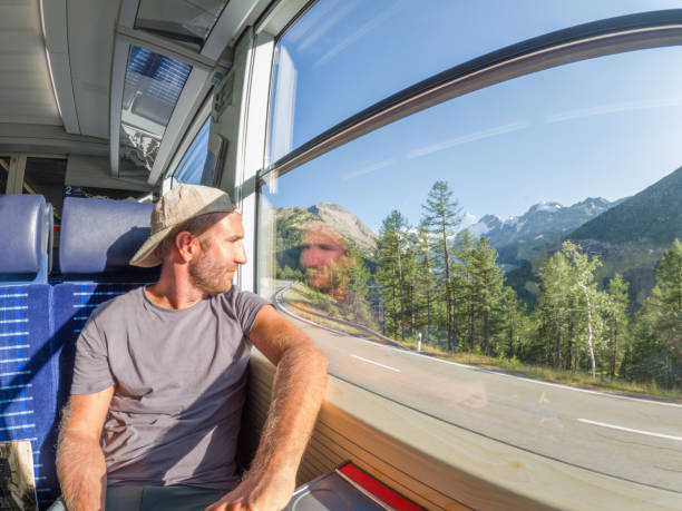 istock Man traveling by train looking from the window enjoying passing scenery 1569263880