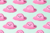 Creative concept of time. Pink clock pattern on turquoise background.