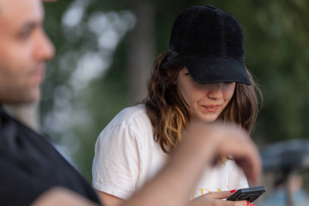 istock Young couple is sitting on the public park bench and talking each other. 1569302103