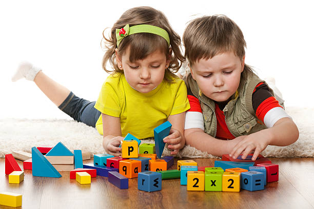 istock Two children playing with colorful blocks on the floor 156930307