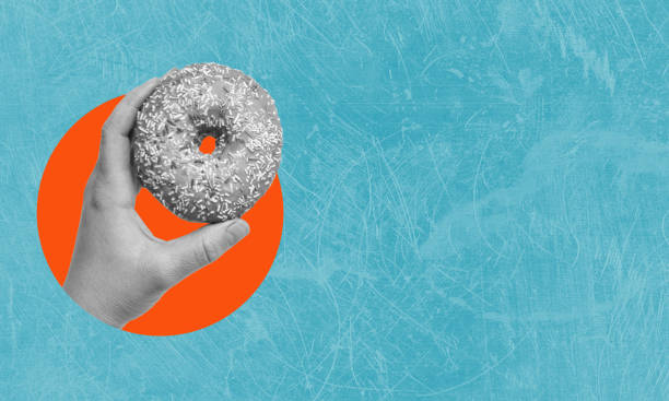 istock Art collage, hand holding donut on blue background with copy space. 1569314600