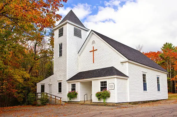 White country church against autumn trees in New England