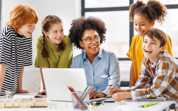 istock Teacher and students watching laptop screen 1569379922