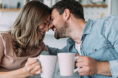 Lovely young couple drinking coffee at home.